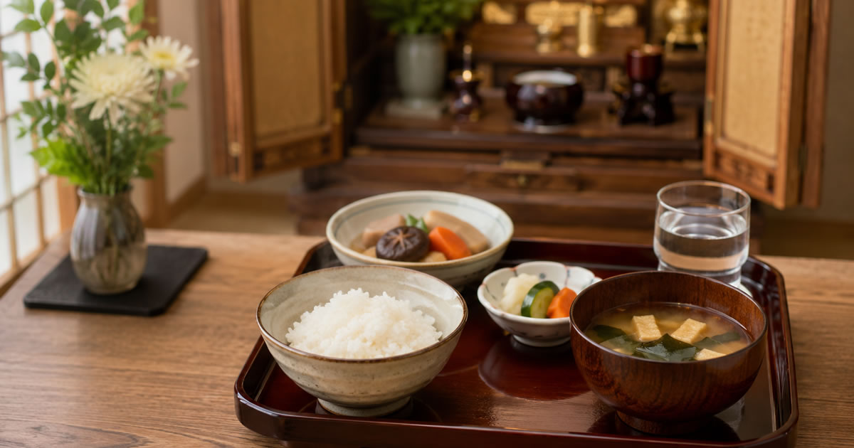 漆塗りの小さな膳に、白いご飯と味噌汁、煮物、香の物、水の入った椀が整えて並べられている精進料理の霊供膳の写真